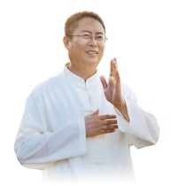 a chinese man in a white robe clapping his hands